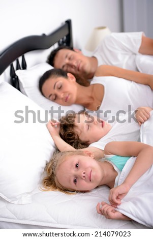 The little girl crying in bed at the time when the mother, father and brother sleep in the bedroom