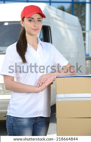 Smiling young male postal delivery courier man in front of cargo van delivering box