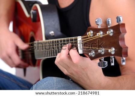 Young musician playing guitar, isolated on white