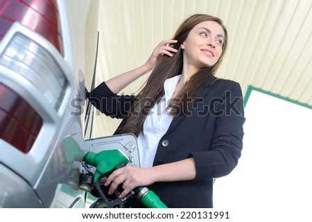 Business woman on filling station, while filling your car