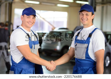 Portrait of two men handshake mechanics in auto repair service