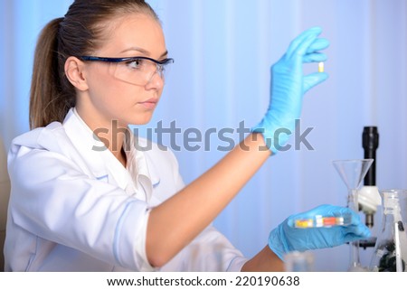 Chemist woman testing sample of liquid in laboratory