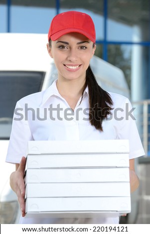 Female courier delivery pizza on background car for pizza delivery