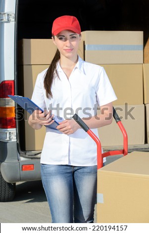 Portrait of female delivery driver with clipboard and box