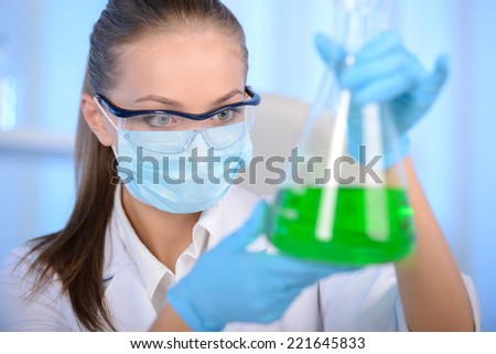 Chemist woman testing sample of liquid in laboratory