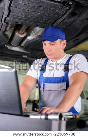 Professional mechanic using a laptop computer to check a car engine