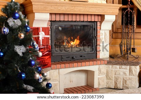 Christmas tree and boxes with gifts for family, fireplace background.