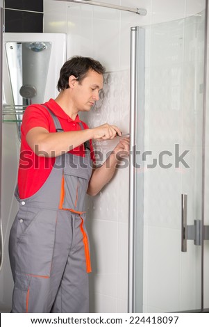 Professional plumber. Plumbing repair service. Plumber repairing a shower.