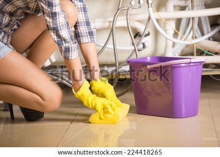 Woman is cleaning the floor. A bucket of water.