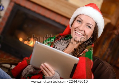 Young woman near fireplace in Christmas decorated house interior
