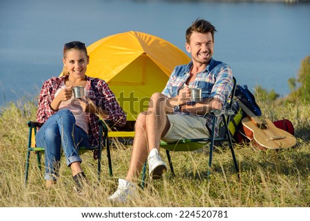 Young couple tourists, drinking tea near the tent camp