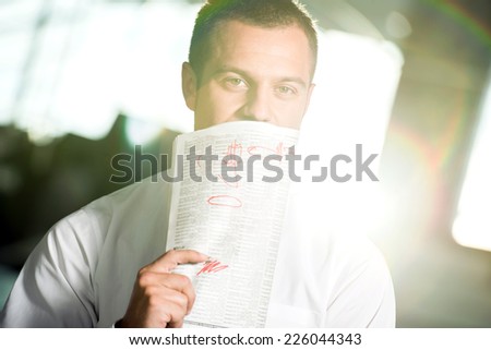 Young man with the newspaper, he is looking for a job.