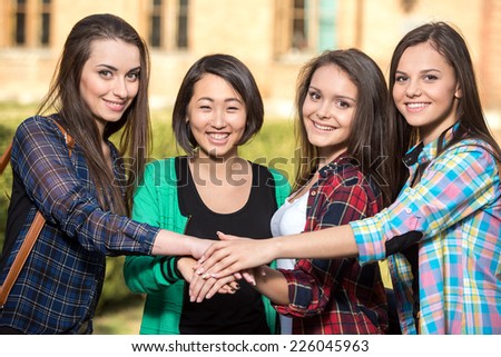 Portrait of young beautiful female students with university building in the background.