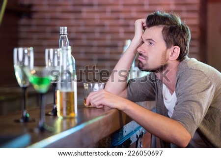 Young drunk man drinking alcohol in the bar