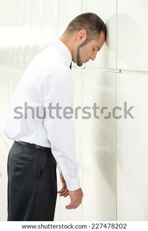 Unemployed man, stressed for there is no work. Beats head against wall.