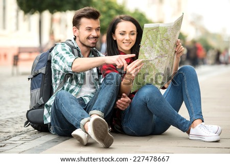 Young happy tourists is sightseeing city with map.