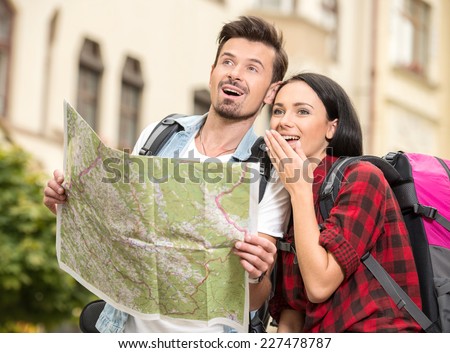 Portrait of young tourist couple use their map and pointing where they want to go.