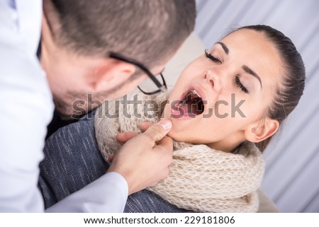 Doctor consulting a young woman, sore throat concept.