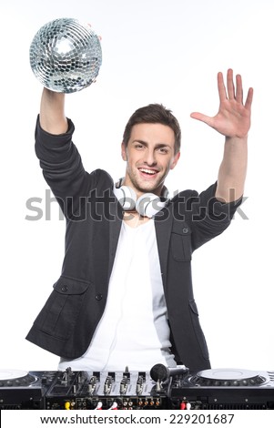 Portrait of a young man with a mirror ball and dj mixer on a white background.