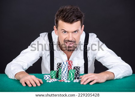 Portrait of a poker player man with chips in casino.