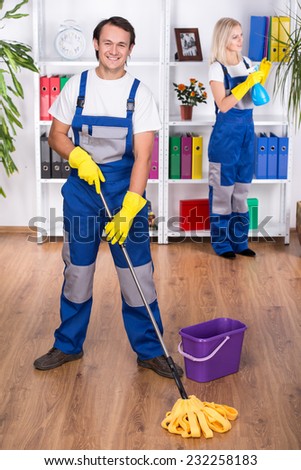 Young couple professional cleaners are cleaning the office.