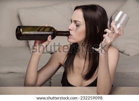 Young beautiful woman in depression, is drinking alcohol.