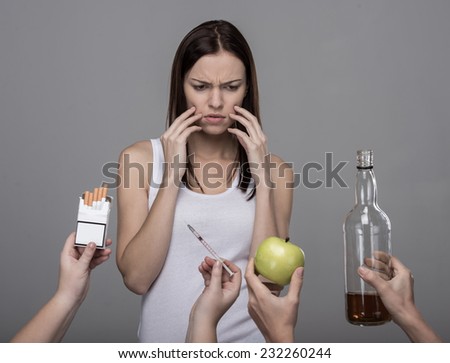 Concept of bad habits. A young woman, alcohol, drugs, tobacco. Young girl struggling with her bad habits.