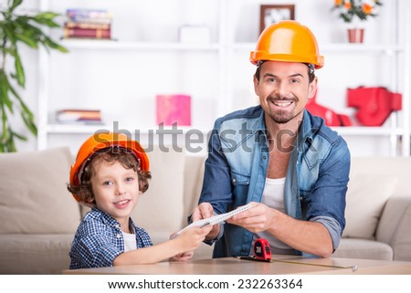 Young happy father teaches his little son tinkering.