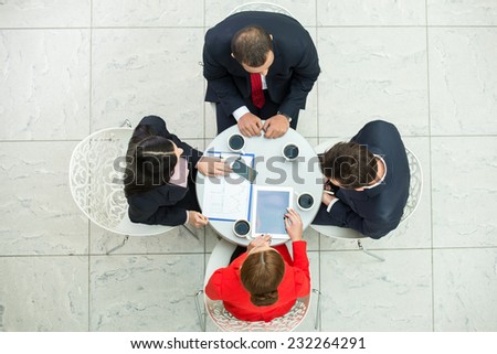 Above view of several business people are planning work at round table.