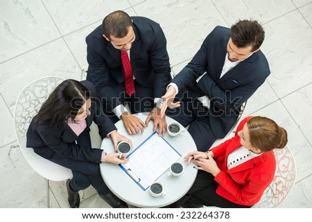 Top view of several business people are discussing business plans at round table.