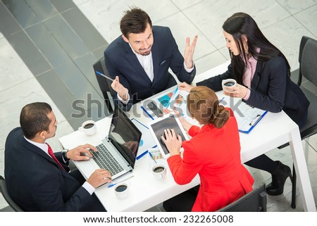 View from above of several business people are planning work around table.