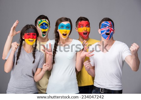 International team. Five emotional young people with national flags painted on the faces.