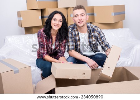 Happy couple in new apartment with a lot of boxes.