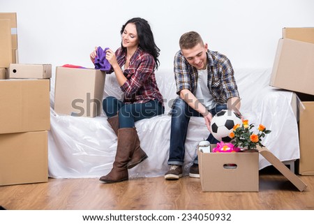 Couple are moving into a new home and unpacking boxes.