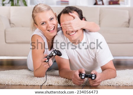 Happy couple are spending time together. Playing computer game.