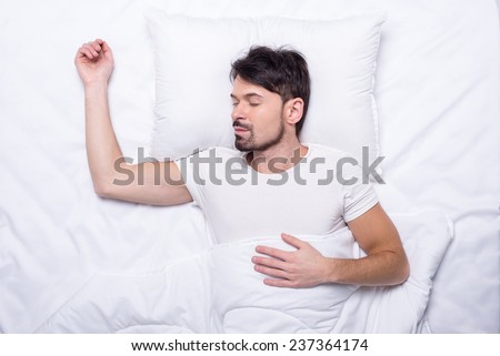 Top view of young man is sleeping in the bed.