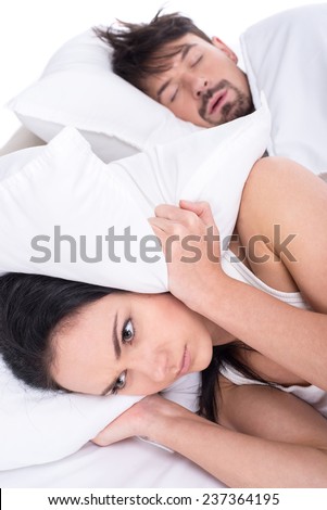 Woman is trying to fall asleep while man is snoring.