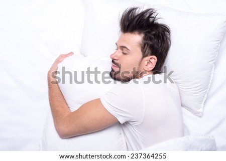 Top view of young man is sleeping in the bed.
