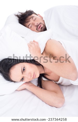 Woman is trying to fall asleep while man is snoring.