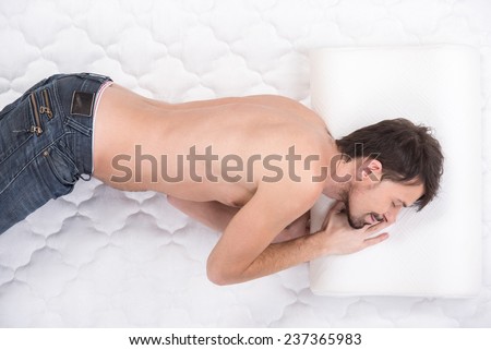 Orthopedic mattress. A young man is sleeping on a mattress.