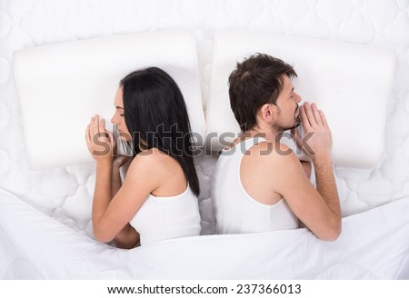 Young couple is sleeping on the mattress. Top view.