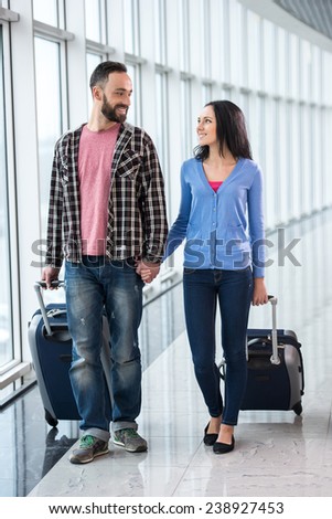 Young couple with luggage bags at airport are ready to flight.