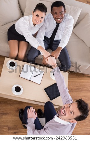 Top view of business people are shaking hands while working in cosy meeting room.