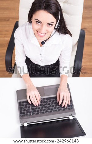 Top view of attractive young woman is working in a call center.