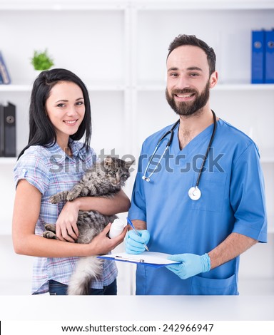 Young woman with her cat on a visit to the vet.