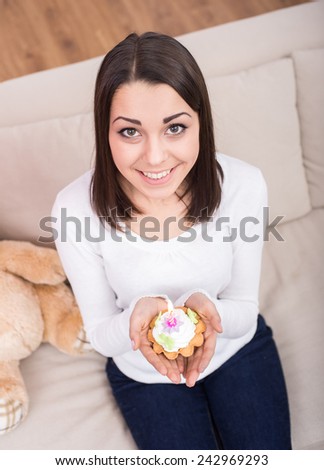 Beautiful happy woman with a birthday cake is looking at the camera. Top view.