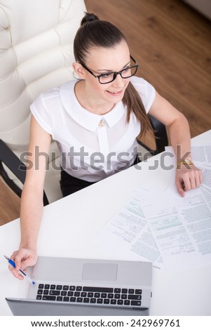 Young, beautiful businesswoman with laptop in office. Top view.