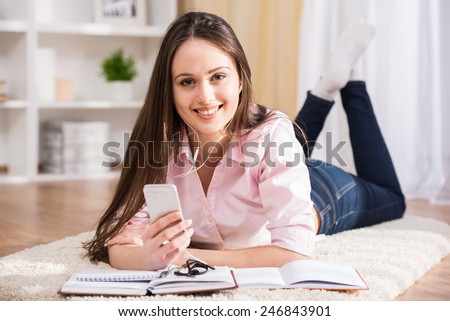 Education and home concept. Smiling student girl is reading books at home.