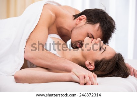 Young love couple in bed, romantic scene in bedroom.