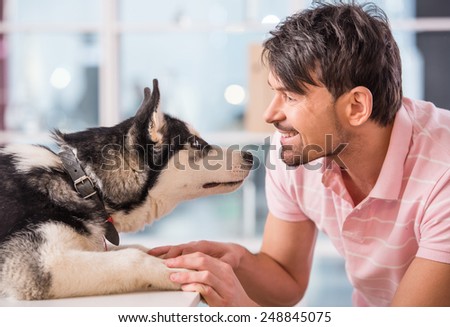 Close-up of happy man is looking at dog, husky.